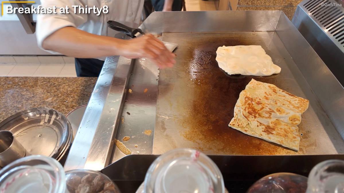 Staff cooking roti canai at the breakfast buffet