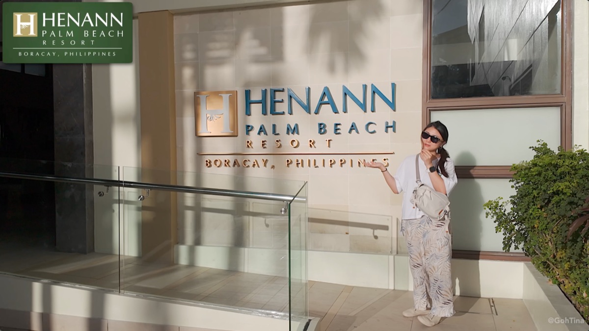 Posing by the Henann Palm Beach Resort sign at the entrance